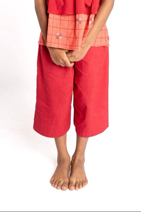 Young girl wearing a red dress with a white background