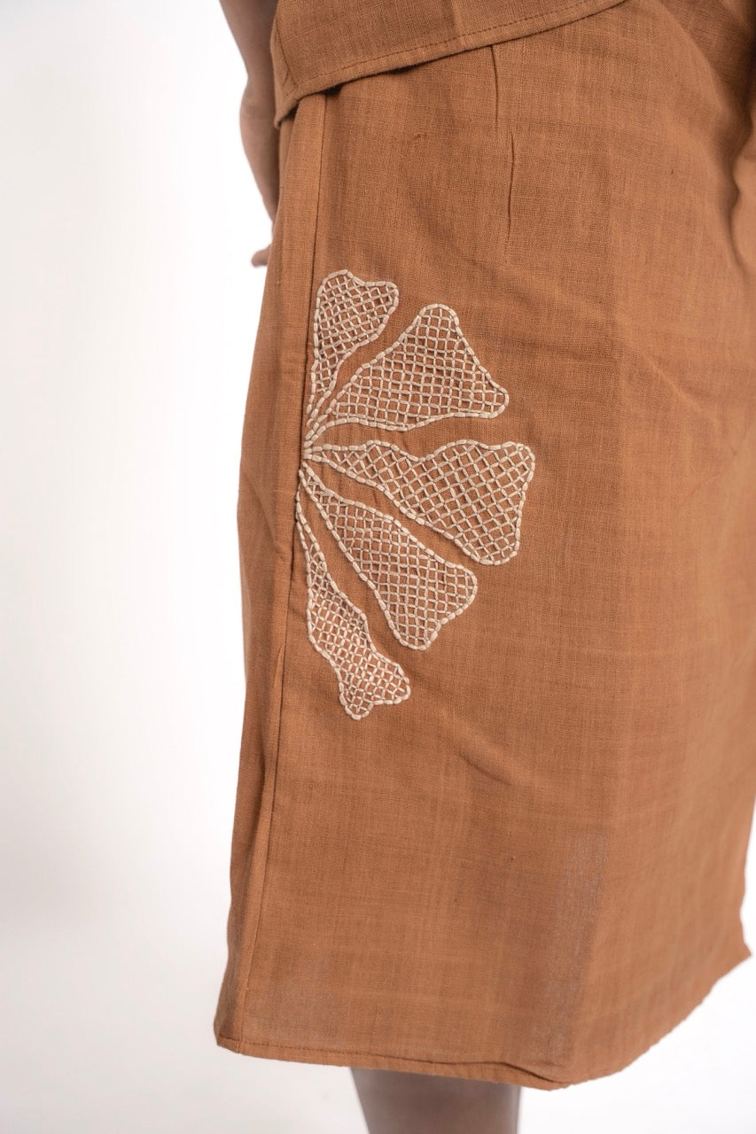 Brown skirt with white floral embroidery on a white background