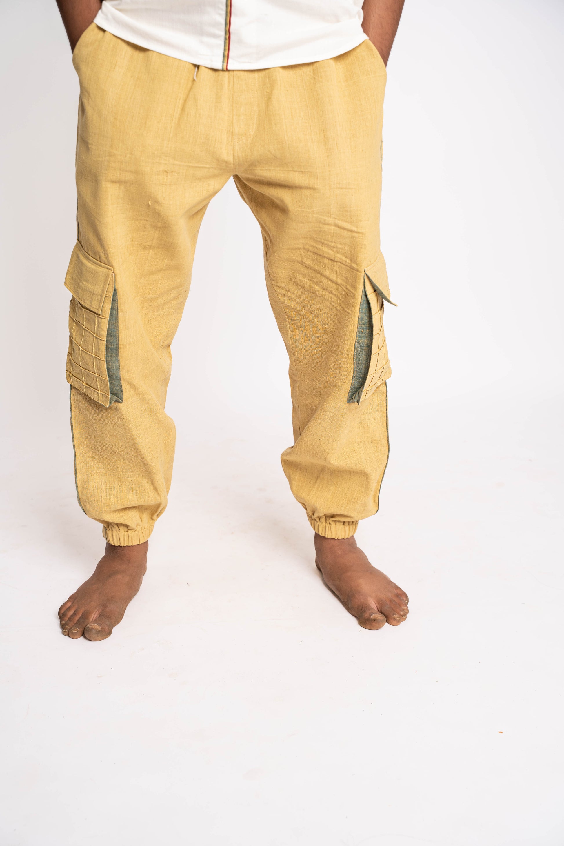Yellow cargo jogger pants worn by a person on a white background