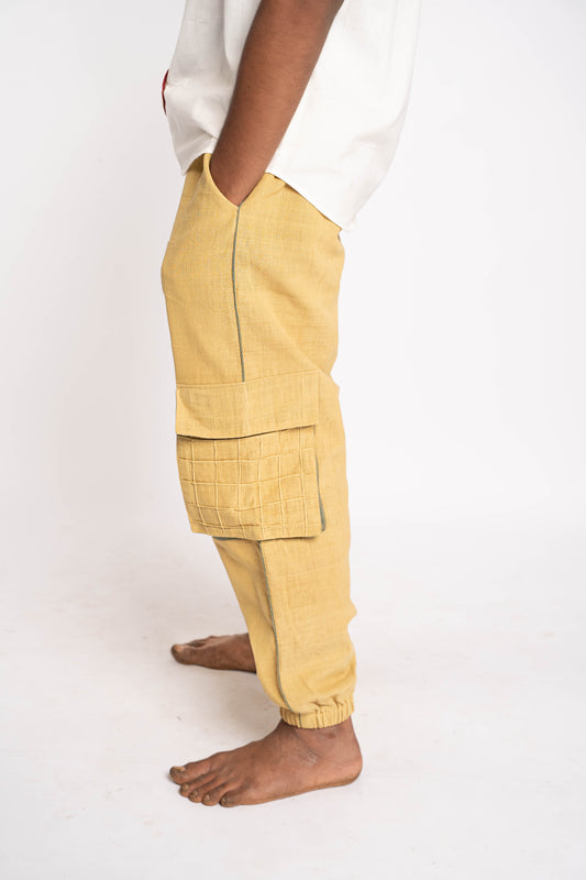 Yellow cargo pants worn by a person on a white background