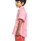 Child wearing a pink shirt and red shorts on a white background