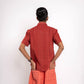 Person wearing a red shirt and orange shorts on a white background