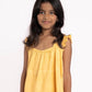 Young girl wearing a yellow top and shorts on a white background
