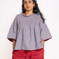 Woman wearing a gray top and red shorts on a white background