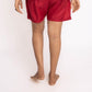 Person wearing a gray shirt and red shorts on a white background