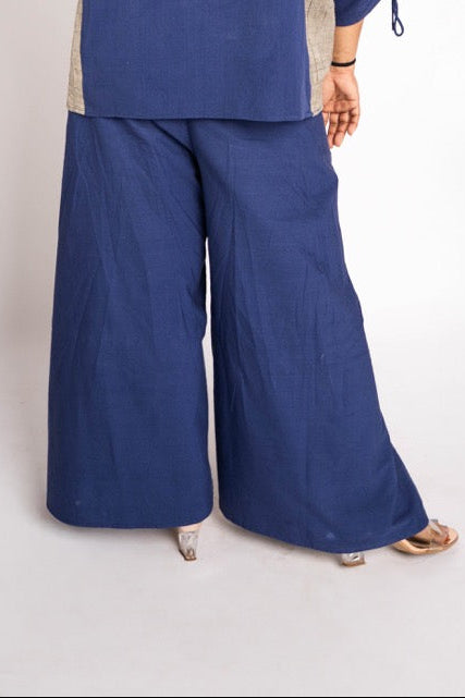 Person wearing a blue outfit with wide-leg pants on a white background