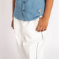 Child wearing a blue shirt with buttons and white pants on a white background