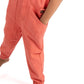 Coral jumpsuit worn by a person on a white background