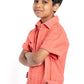 Young boy wearing a peach-colored shirt and pants on a white background