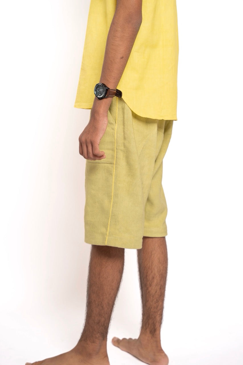 Person wearing yellow shorts and a yellow top on a white background
