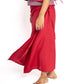 Person wearing a red outfit with a flowing skirt on a white background
