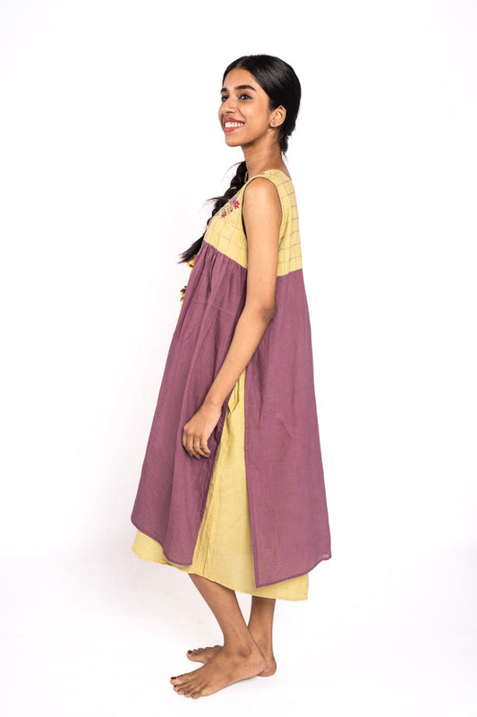 Woman wearing a two-tone dress with purple and yellow on a white background