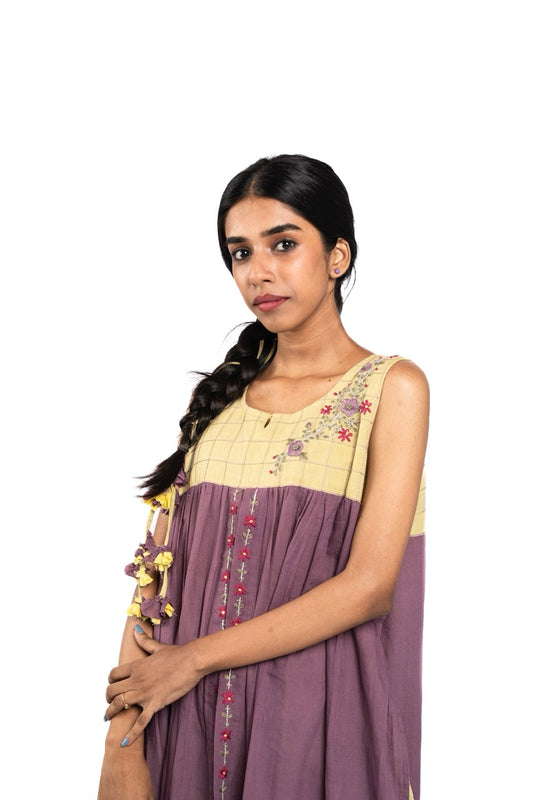 Woman wearing a traditional outfit with a purple and yellow dress on a white background